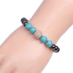 Detail view of turquoise and black magnetic beaded bracelet on wrist with lava stone accents