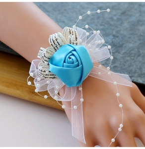 Détail du corsage de poignet rose en ruban bleu avec perles et organza pour mariages