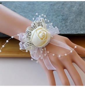 Détail de fleur de poignet pour mariée en satin crème avec perles et rubans en organza