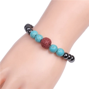 Detailed view of beaded bracelet featuring turquoise, black stones and brown lava rock