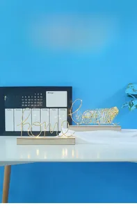 Makroansicht von LED-Leuchten in Home- und Love-Form mit Holzsockel für Schlafzimmerdeko