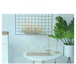 Detail der LED Home und Love Leuchte mit hellem Holzsockel und Goldmetalldrähten