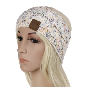 Close-up of cable knit winter headband with colorful flecks and a C.C leather patch