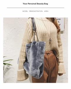 Detailed side view of a grey faux fur tote bag with black leather and silver chain strap