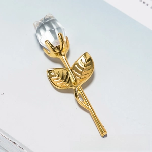 Macro detail of faceted crystal rose head with golden metal stem and leaves