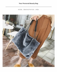 Detail of grey plush tote bag featuring soft faux fur texture and metal chain handles