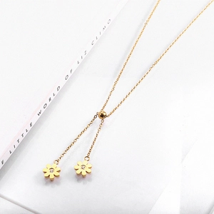 Detail of gold daisy sunflower necklace featuring sparkling crystal center on a white surface