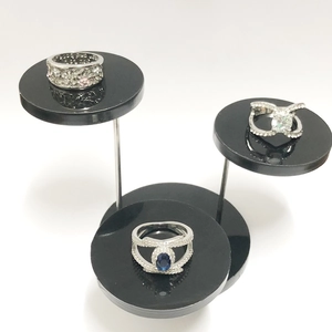 Three-tier acrylic stand displaying diverse silver rings with colorful zircon gemstones