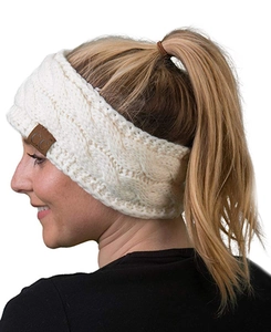 Close-up of white knitted headband with cable knit texture and leather CC logo tag