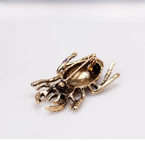 Detailed back view of vintage gold beetle brooch with secure metal safety pin closure