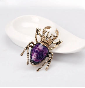 Close-up of vintage beetle brooch with purple gradient glitter shell and crystals