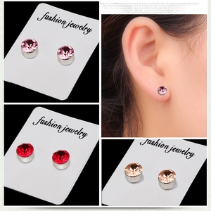 Magnetic stud earrings with round faceted colorful crystals on a white display card