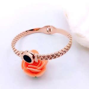 Detail of rose gold bangle with Roman numerals and black onyx-style round inlay