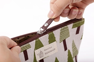 Close-up detail van canvas cosmetische etui met gladde rits en mooi geweven stoffen label.