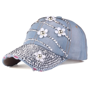 Dettaglio del berretto da baseball in denim azzurro con strass argentati e decorazioni floreali 3D