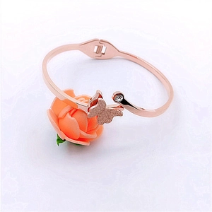 Detail of rose gold butterfly bangle featuring a small diamond setting and frosted finish