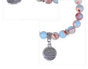 Macro shot of natural stone bead bracelet with a detailed Tree of Life silver pendant