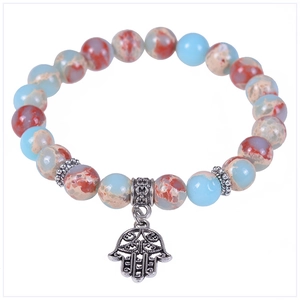 Detailed macro view of snake skin stone bracelet with Hamsa Hand and Tree of Life charm