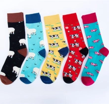 Flat lay of colorful crew socks featuring cow patterns in black, blue, yellow, and red