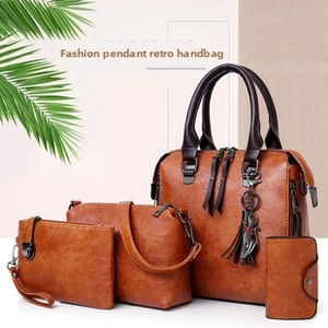 Detailed set of four vintage brown leather handbags including a tote with cat charm