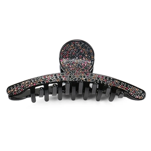 Detail of a black hair claw clip featuring sparkling colorful rhinestones on a white background