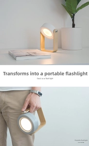 Portable LED lantern lamp being used as a handheld flashlight with wooden handle detail