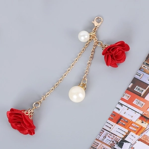 Detail of creative phone lanyard with red fabric rose, faux pearls and gold lobster clasp