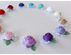 Detailed close-up of handmade satin rose wrist corsages with pearls and lace decor