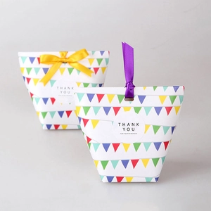 Colorful paper gift boxes with triangle patterns, yellow and purple ribbons for favors