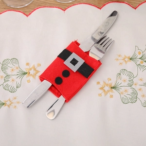Christmas Santa suit cutlery holder in red felt on festive white embroidered tablecloth