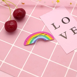 Colorful rainbow patterned metal BB hair clip for girls on a pink decorative background