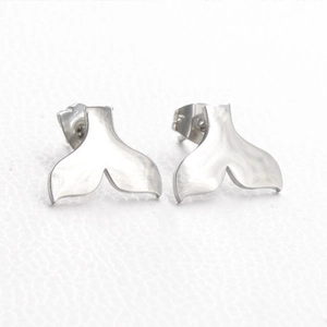 Close-up of silver-toned stainless steel mermaid tail stud earrings with a mirror finish