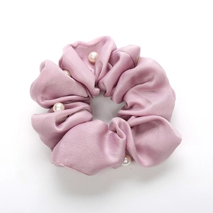 Chouchou en satin lilas avec perles élégantes pour coiffure sur fond blanc