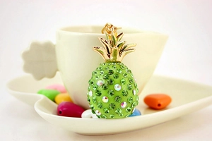 Detailed close-up of a sparkling resin pineapple keychain with green and white rhinestones