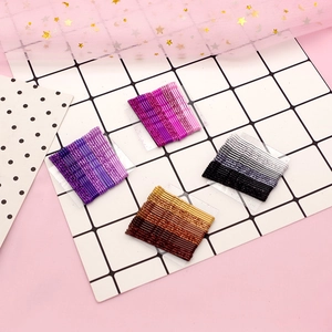 Set of glitter metal bobby pins in purple, pink, brown, and gray gradient colors