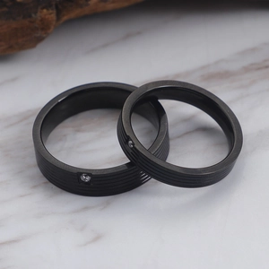 Pair of black titanium steel couple rings with grooved texture and small zircon stone