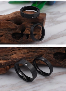 Detail of a minimalist black titanium steel ring with a single diamond on marble