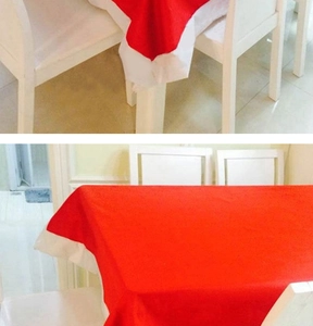 Detail of red and white festive Christmas tablecloth on a white wooden dining table