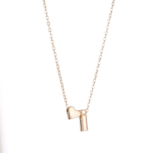 Detail of rose gold heart pendant necklace with rectangular bar charm on curb chain