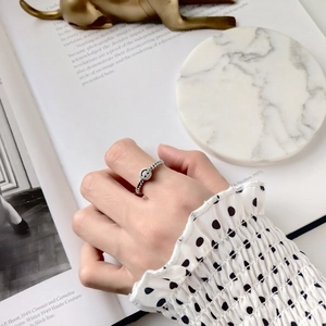 Macro detail of silver smile ring featuring a twisted band and retro engraved smiley face