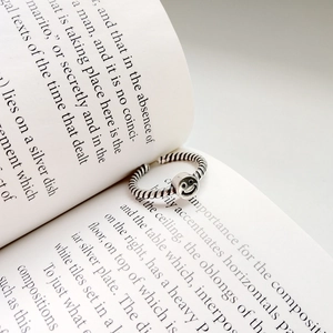 Detail of vintage S925 sterling silver smile ring with a twisted band on a book