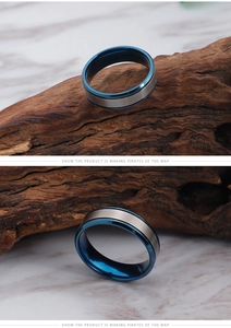 Detail of blue titanium steel ring with brushed silver surface on wooden stand