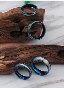 Detailed view of silver and blue titanium steel rings on rustic wood over marble surface