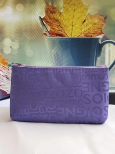 Close-up of purple jacquard toiletry bag with letter pattern and zipper detail