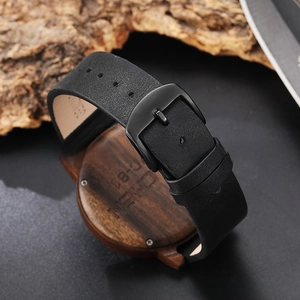 Macro detail of the wooden watch case back and genuine black leather strap with buckle