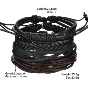 Close-up detail of multi-layer handmade leather bracelet with braided rope and metal charms