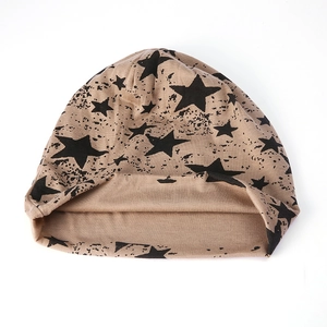 Détail d'un bonnet kaki avec motif d'étoiles noires et tissu en tricot de coton doux