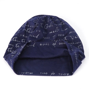 Close-up of navy blue knit beanie with all-over light grey cursive text pattern