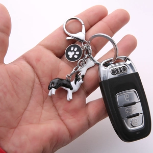 Detail of Border Collie keychain with paw print tag and silver bone charm