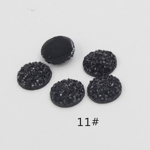 Macro view of 12mm black round resin stones with sparkly crystal texture and flat back